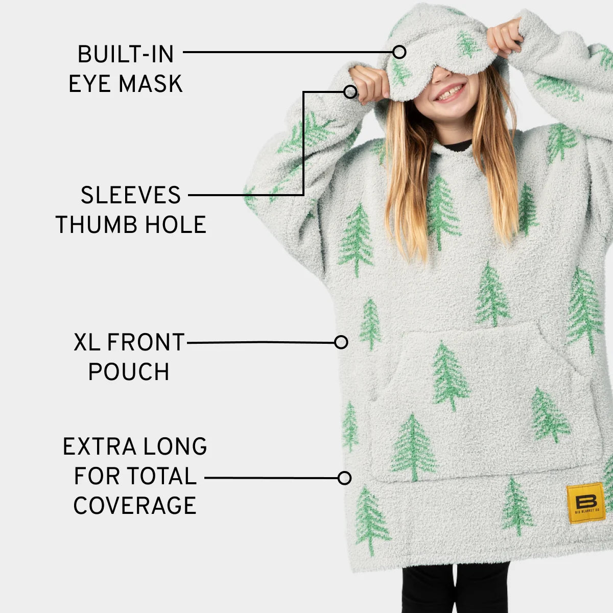 Cream and green tree-patterned oversized hoodie blanket with built-in eye mask, thumb holes, and front pouch