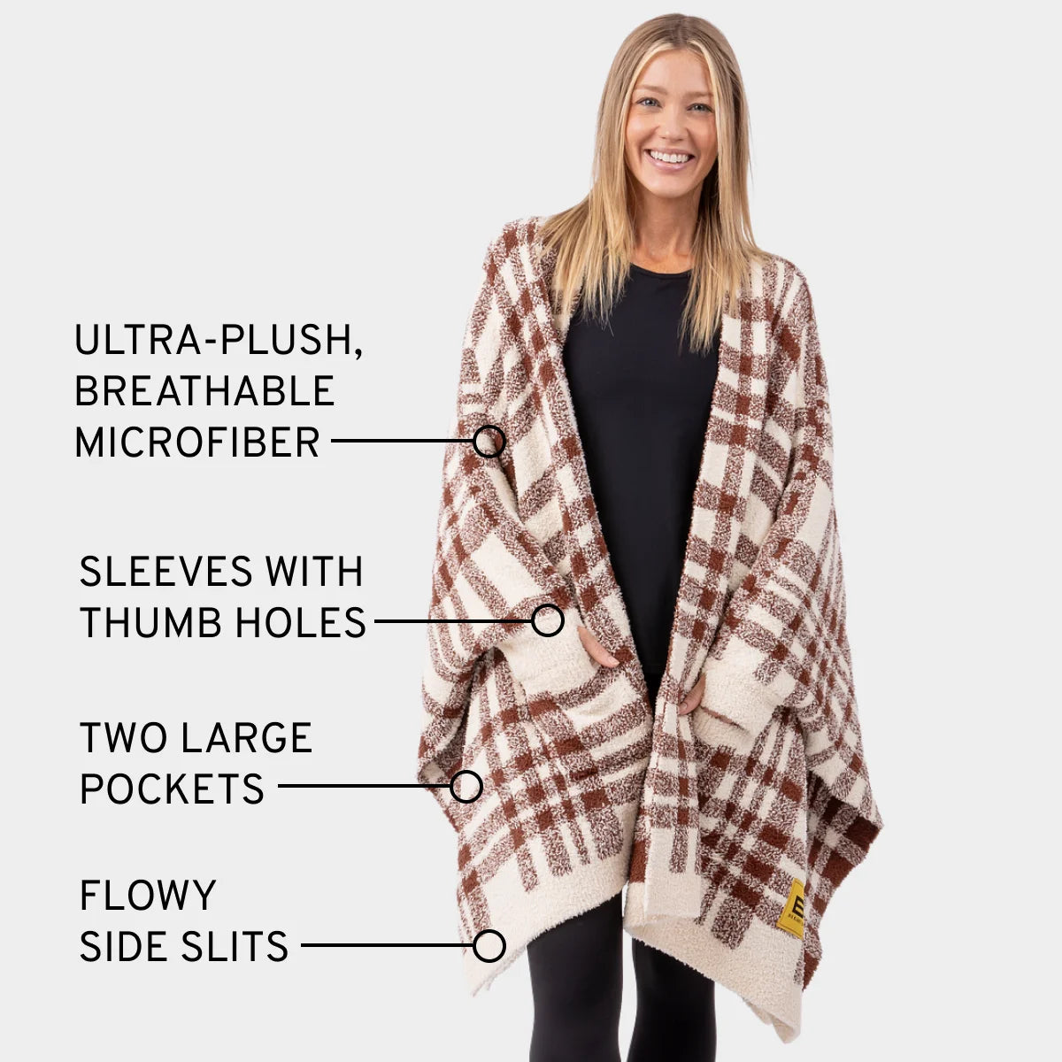 Woman wearing terracotta plaid Premier Plush Wrap with thumb holes, pockets, and side slits