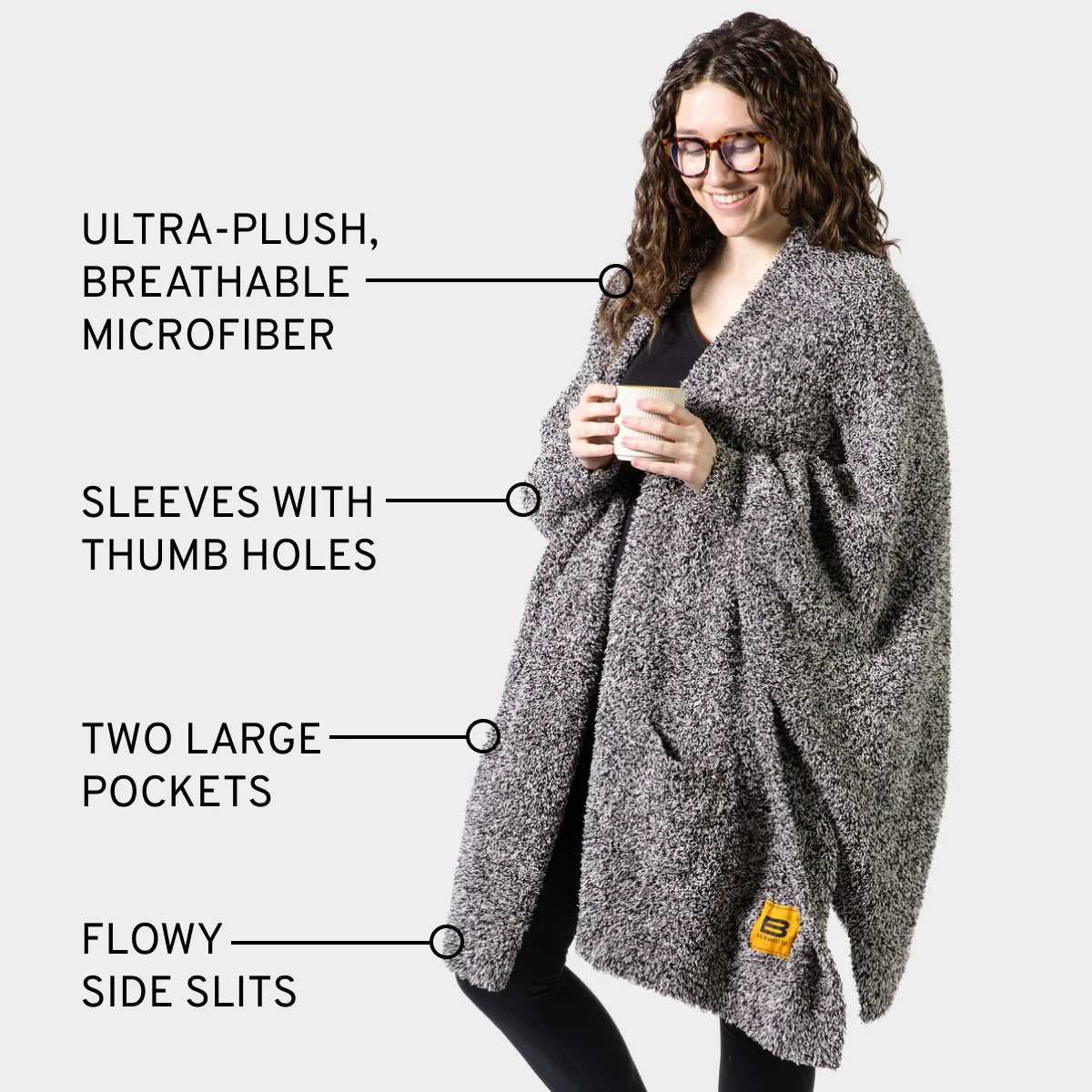 Woman wearing gray heather wearable blanket wrap with thumb holes, pockets, and side slits