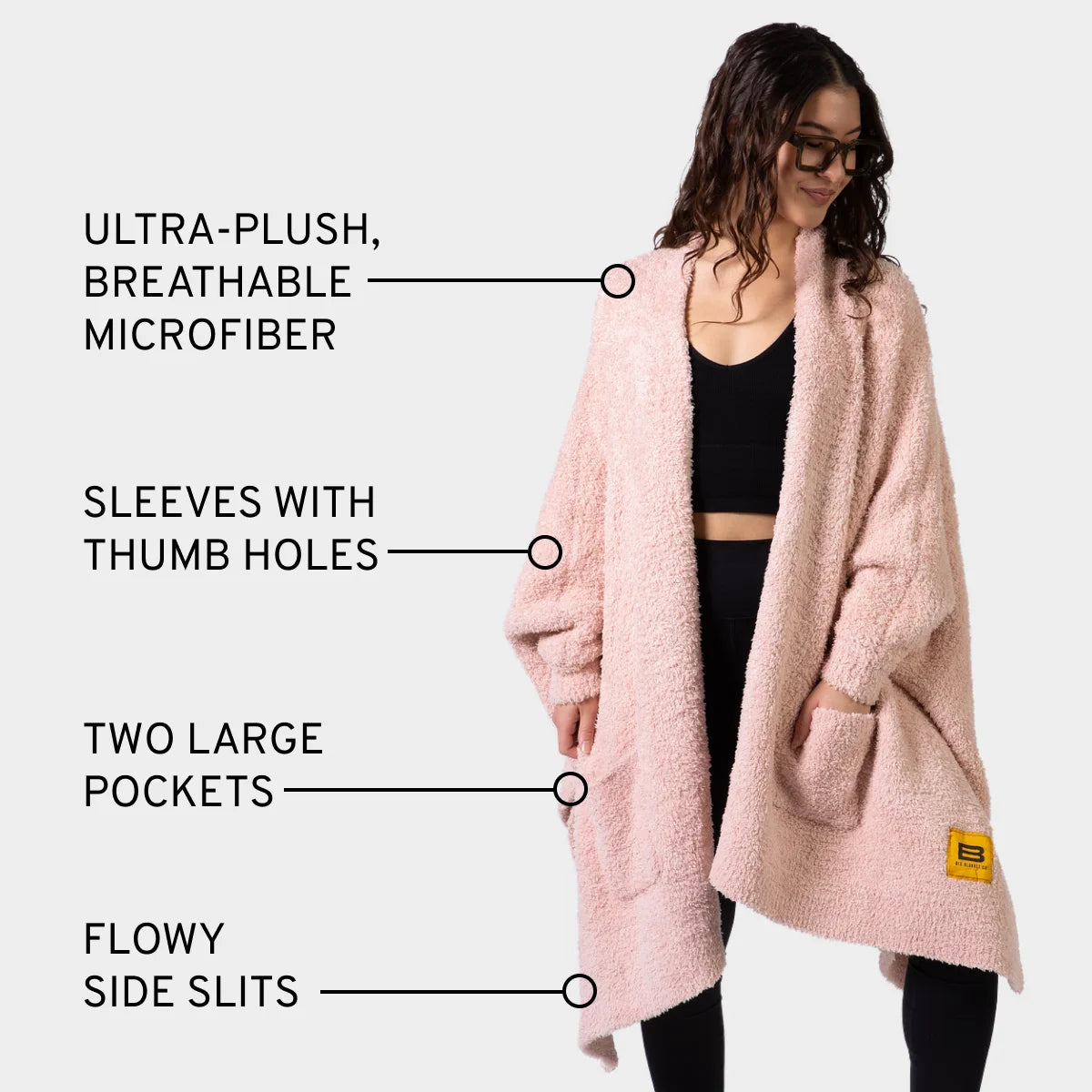 Blush Premier Plush Wrap worn as oversized blanket with sleeves, thumb holes, and pockets