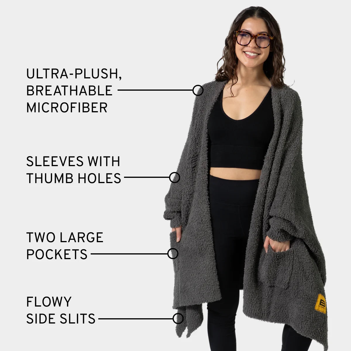 Charcoal Premier Plush Wrap worn as oversized blanket with sleeves, thumb holes, pockets, and side slits