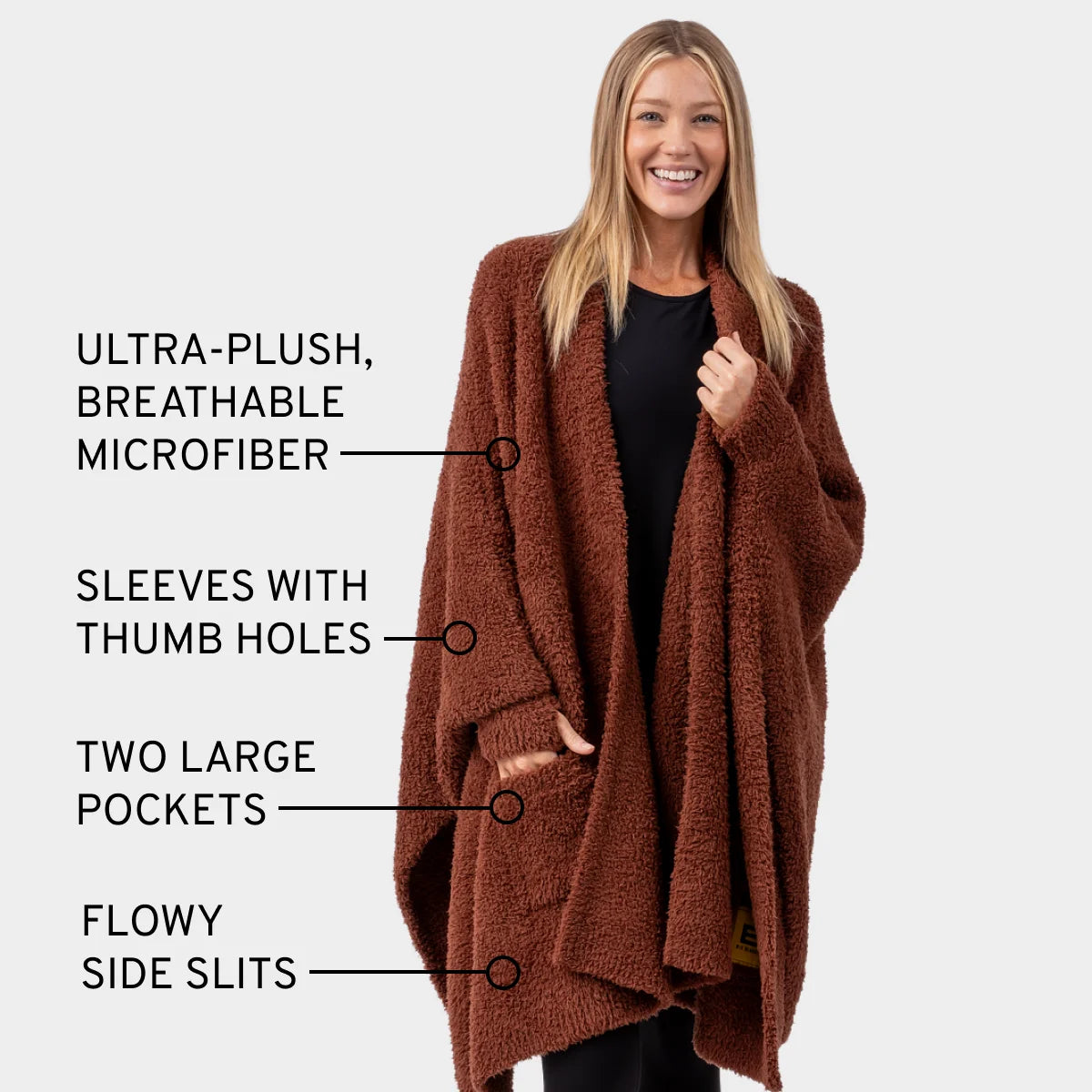 Woman wearing chocolate brown oversized blanket wrap with thumb holes, pockets, and side slits