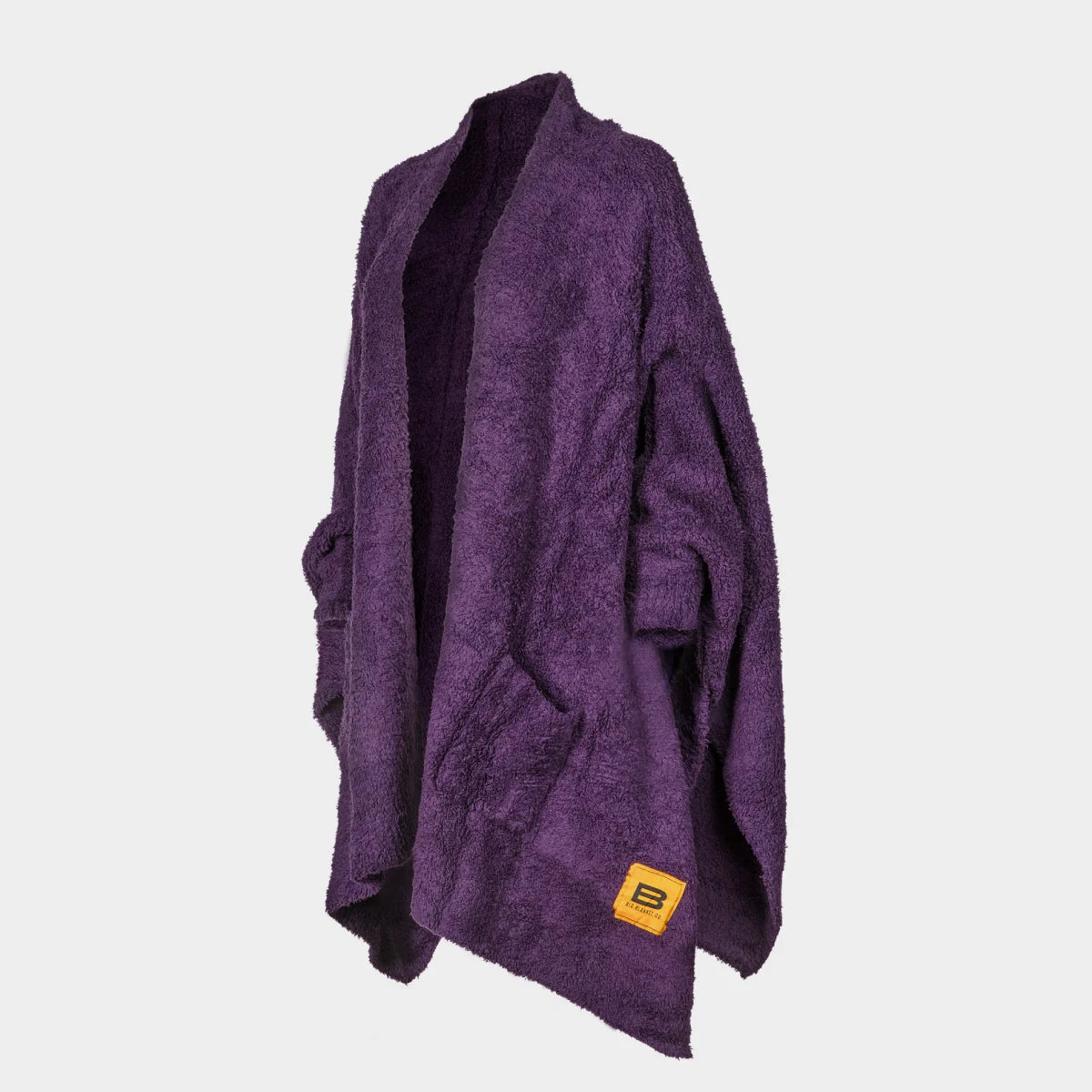 Deep purple oversized blanket wrap with textured plush fabric and yellow brand label