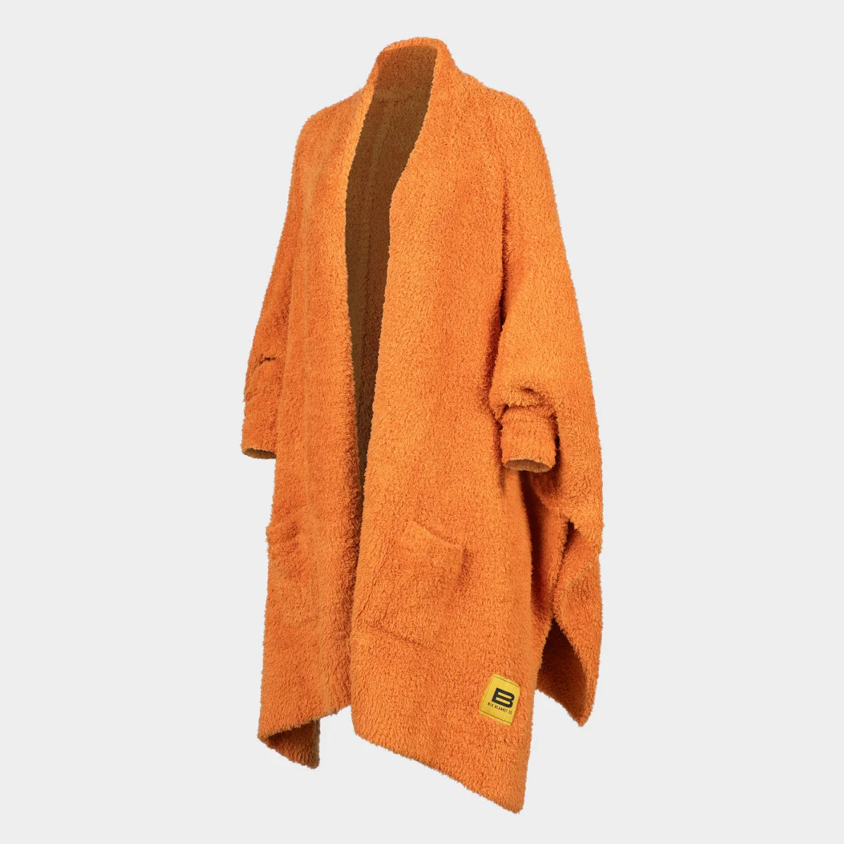 Burnt orange Premier Plush oversized blanket wrap draped on form, showing textured fabric and brown interior lining