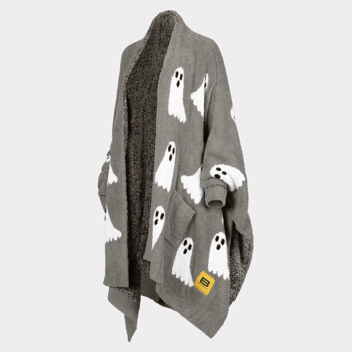 Gray oversized blanket with white ghost pattern and dark textured reverse side, draped over person's shoulders