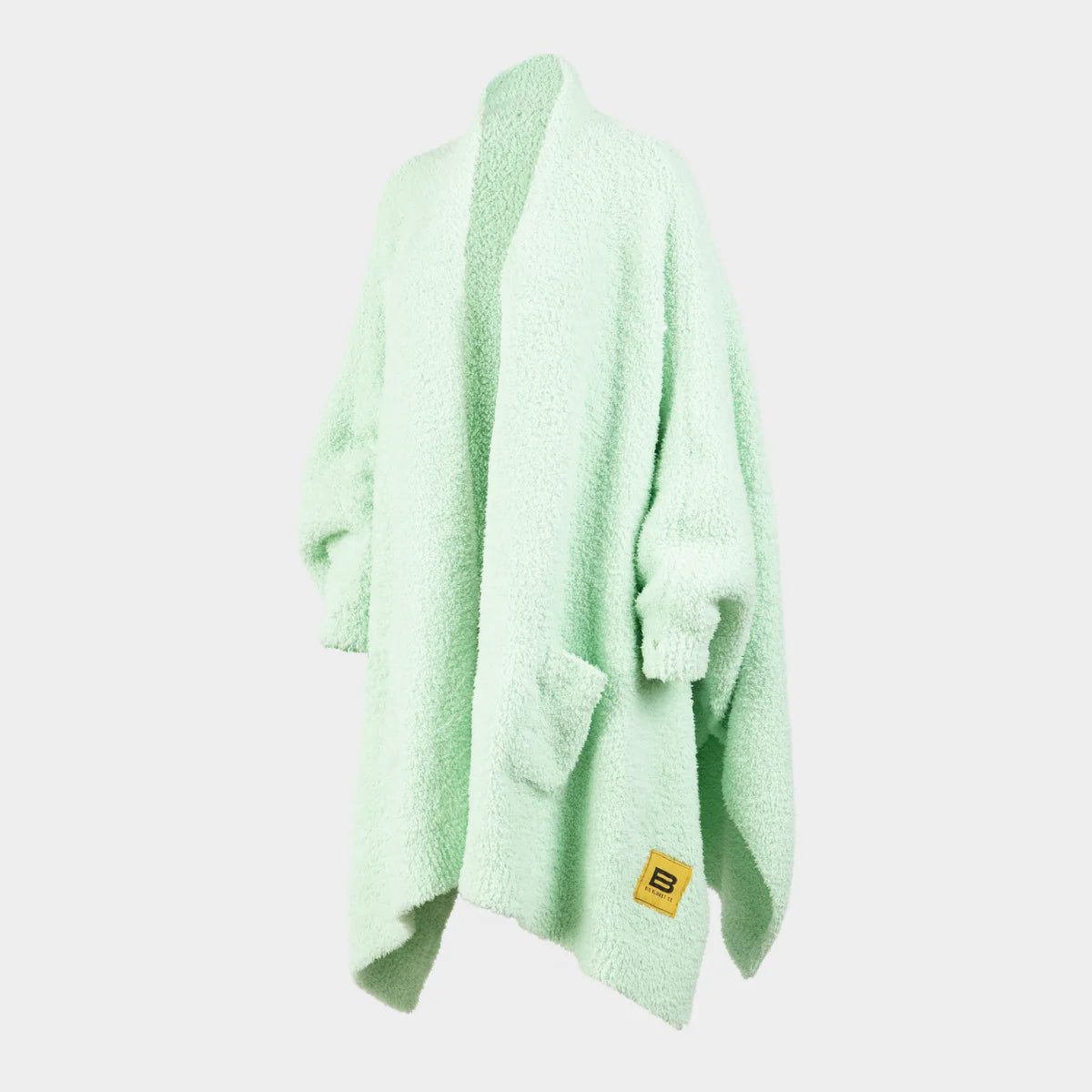Mint green oversized blanket wrap draped on shoulders, showing soft textured fabric and yellow Big Blanket Co logo tag