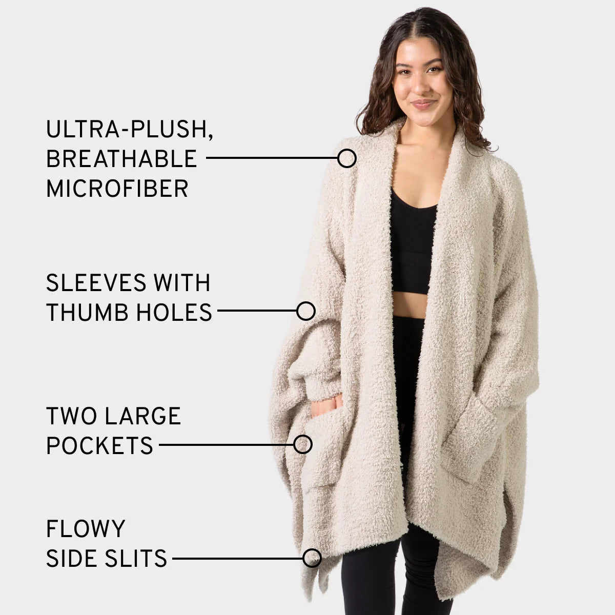 Woman wearing oatmeal Premier Plush Wrap with thumb holes, pockets, and side slits