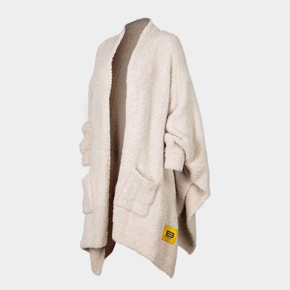 Oatmeal oversized wrap blanket with textured fabric, open front design, and yellow brand label