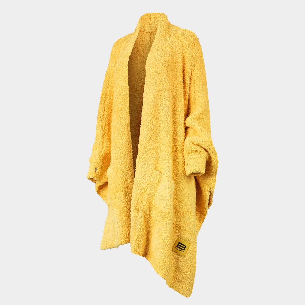 Bright yellow Premier Plush oversized wrap blanket draped over shoulders, showing soft textured fabric and brand logo tag