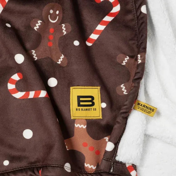Brown oversized blanket with gingerbread men, candy canes, and white dots holiday pattern, Big Blanket Co logo