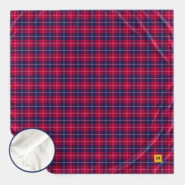 Red and navy plaid oversized blanket with soft white sherpa backing detail shown